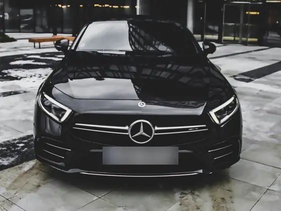 Black Mercedes-Benz sedan parked outside a modern building