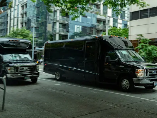 Black mini coach buses on a city street