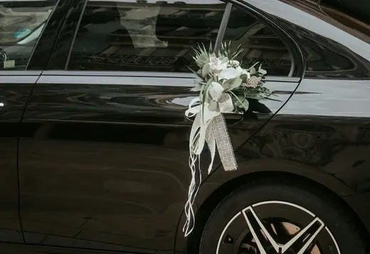 Black Mercedes-Benz decorated with a wedding bouquet